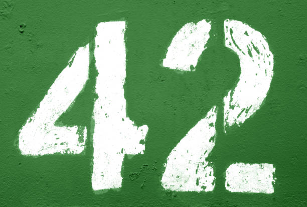 istock Number 42 in stencil on rusty metal wall in green tone. 1138242303