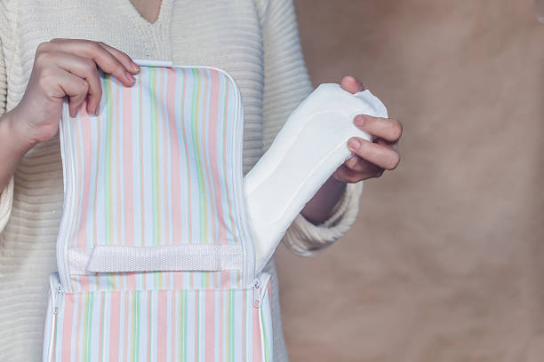 Women hold a menstrual pad. Young woman taking out a sanitary pad from her bag. White menstrual pad Women hold a menstrual pad. Young woman taking out a sanitary pad from her bag. White menstrual pad. Sanitary woman hygiene. menstruation photos stock pictures, royalty-free photos & images