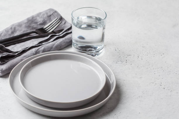 empty plate and glass of water, white background. medical fasting concept. - fast water imagens e fotografias de stock