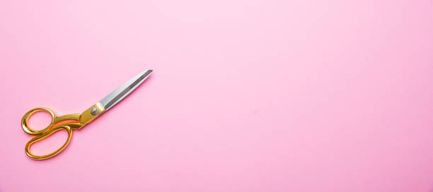 istock Scissors with golden handle on pink background, banne, copy space, top view 1138244381