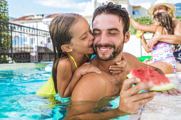 istock daughter hugging her father and having fun in the swimming pool 1138244594