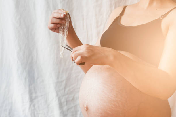 беременная женщина, разрезая презерватив - sexual issues aids condom human pregnancy стоковые фото и изображения
