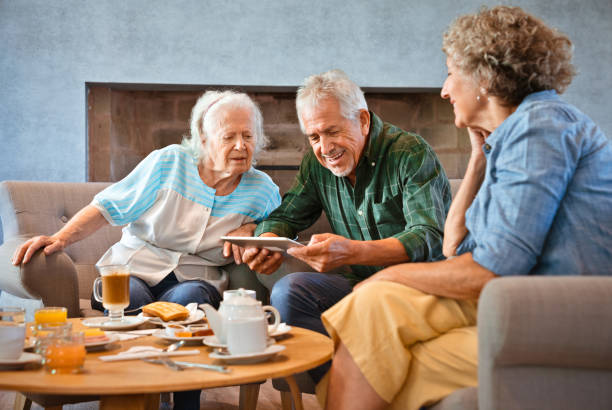 istock Senior man holding digital tablet amidst women 1138248359