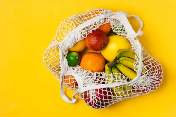 Photo of Organic fruits variety in cotton mesh reusable shopping bag - recycling, sustainable lifestyle, zero waste, no plastic.