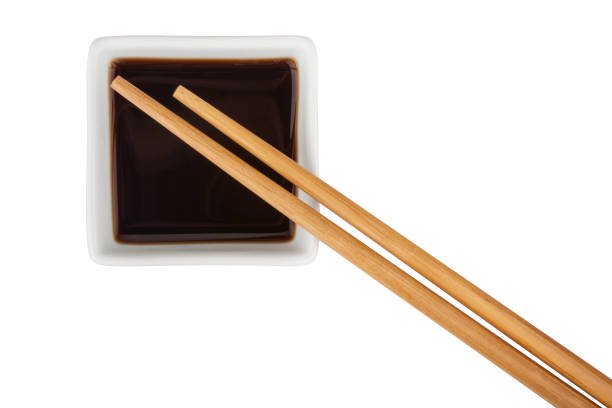 Soy sauce and bamboo chopsticks isolated on white background
