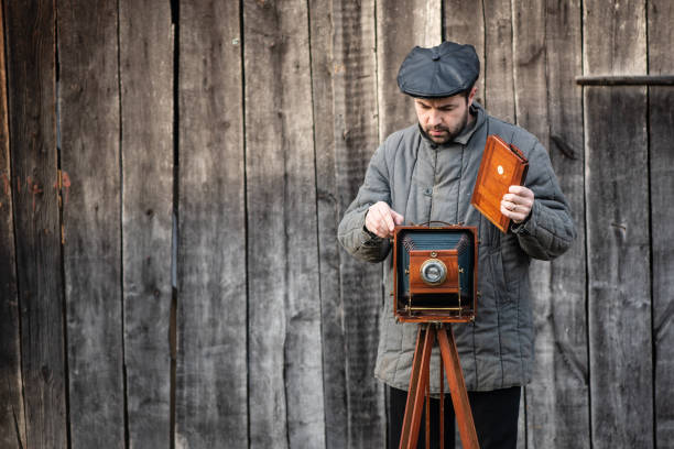 istock Photographer prepares for shooting and inserts film holder into retro large format camera. Concept - photography of the 1930s-1950s 1138248768