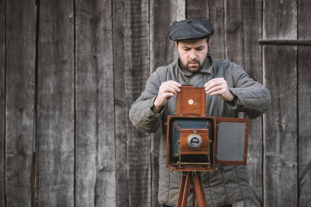 istock Photographer prepares for shooting and inserts film holder into retro large format camera. Concept - photography of the 1930s-1950s 1138248769