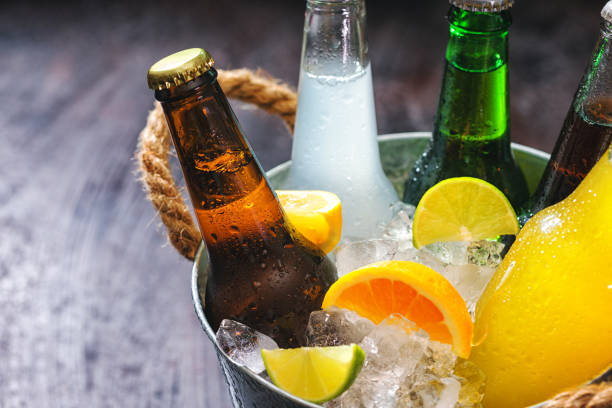 Cold bottles of various drinks in the bucket with ice