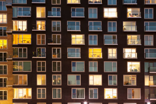 modern apartment block at dusk - house night residential structure illuminated imagens e fotografias de stock