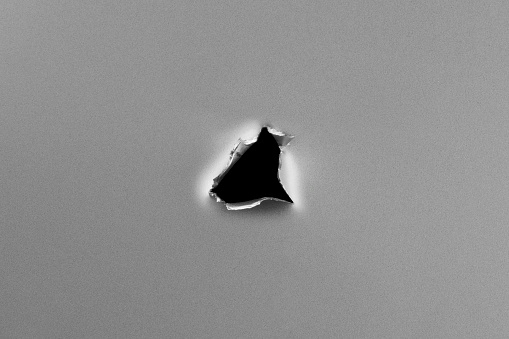 Hole on metal plate. Clean metal background with hole, shot in studio with macro lens.