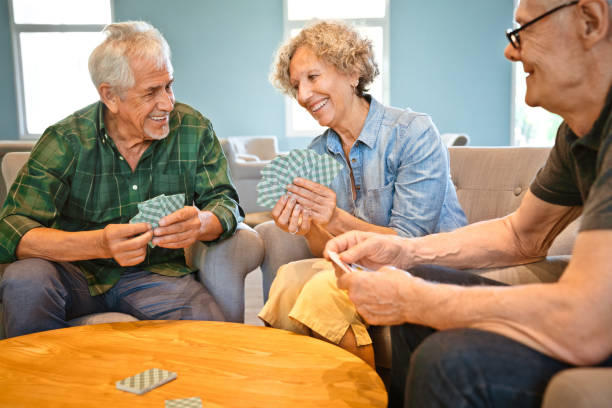 istock Happy elderly friends playing with cards at table 1138252397