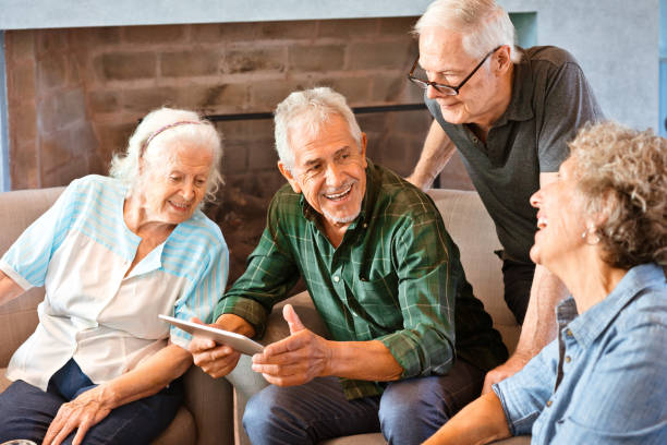 istock Happy senior friends using digital tablet at home 1138252823