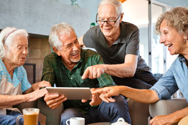istock Happy senior friends with digital tablet on sofa 1138253408