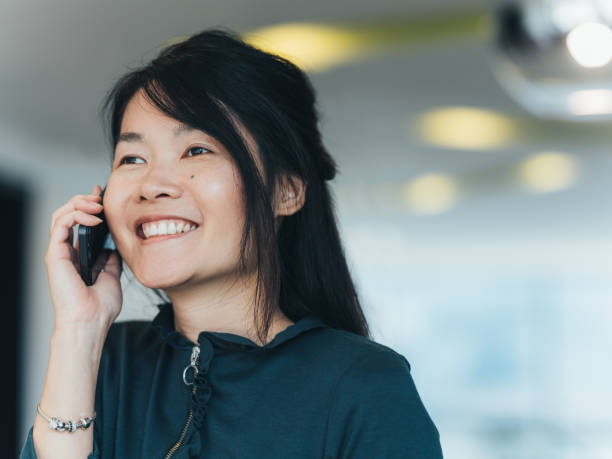 istock Young Asian woman using mobile phone at work 1138253500