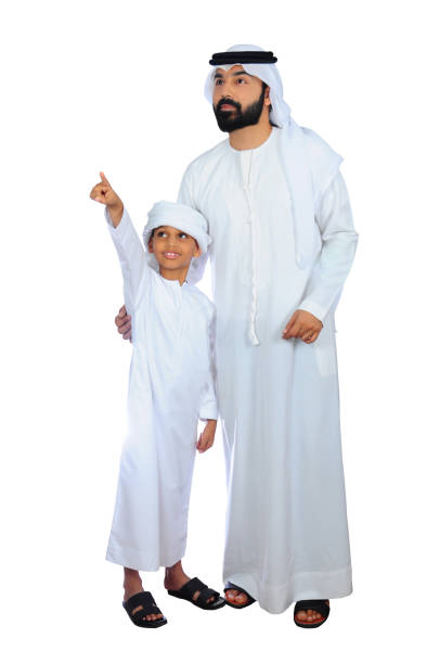 retrato de um pai e de um filho árabes que olham em algo e em desgastar feliz vestido tradicional dos uae - saudi arabia child ramadan offspring - fotografias e filmes do acervo