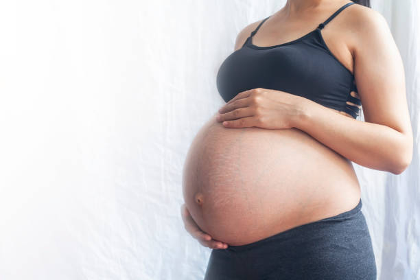ciężarna. 9. miesiąc ciąży. kopiuj miejsce - human pregnancy abdomen naked human hand zdjęcia i obrazy z banku zdjęć