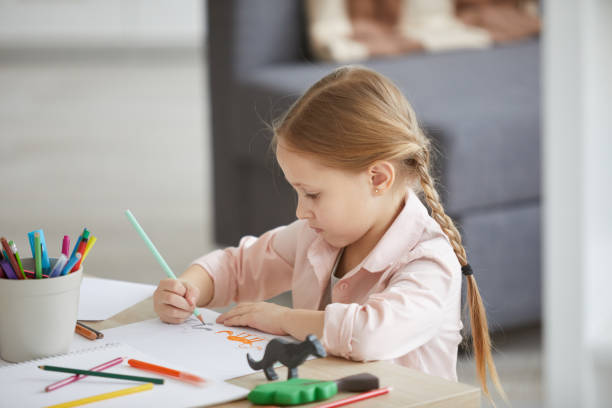 istock Little Girl Drawing Animals 1138257783