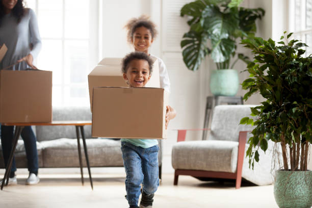 istock Excited small black kids with boxes happy to move in 1138263309