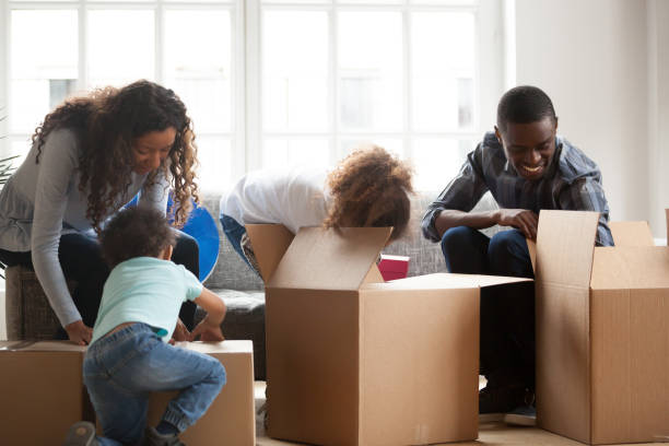 istock Happy black family with small kids unpack boxes 1138263314