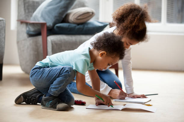 istock Small black siblings drawing together with colorful pencils 1138263330