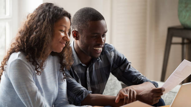 istock Happy mixed race couple check paper bills paying online 1138263353