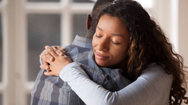 Loving girlfriend hug boyfriend happy to reconcile after fight Happy mixed race woman hug black man husband glad to make peace after fight, loving young girlfriend reconcile with beloved boyfriend, embracing holding in arms. Healthy relationships concept mercy hug stock pictures, royalty-free photos & images