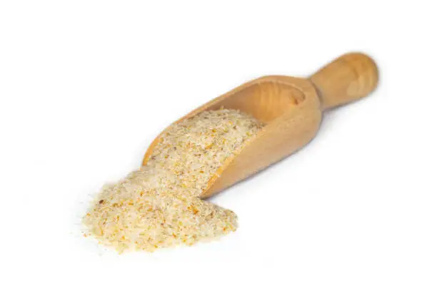Closeup of grounded psyllium or plantago ovata presented on a small wooden scoop