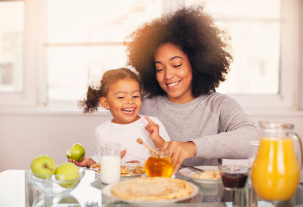 istock African-American young mother and daughter having breakfast 1138269270