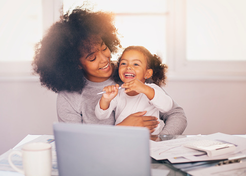 Young mother working and spending time with her daughter