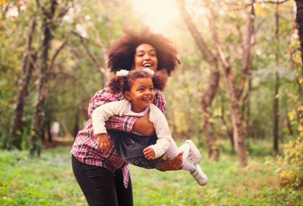 афроамериканская мать и ее дочь. - family grass toddler african descent стоковые фото и изображения
