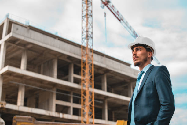 young construction engineer with white helmet crane and construction background - corporate business manager manual worker architect imagens e fotografias de stock