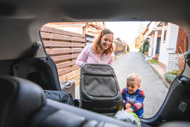 istock Mother and son packing backpacks and suitcases into a car trunk 1138274694
