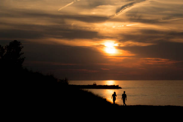 istock couple on the beach during sunset 1138276753