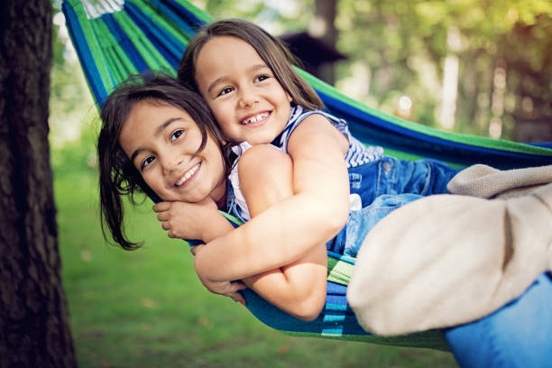 istock Two sisters are hugging in the hammock and make fun 1138281095