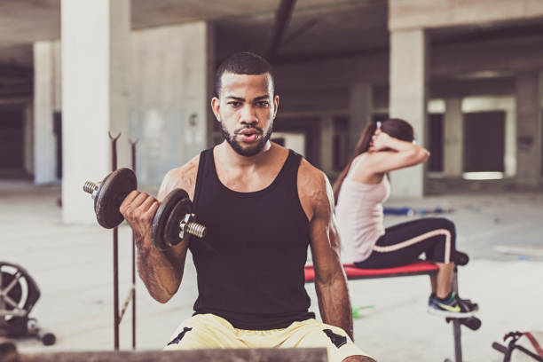 istock Young man lifting dumbbell in a Urban  Gym 1138281747