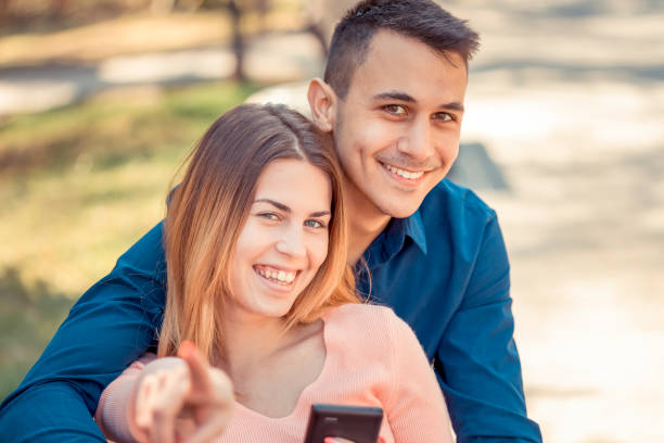 istock Young couple resting in the park and using smartphone 1138282169