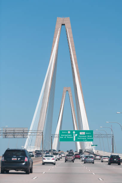 green sign on highway road street with modern urban building white futuristic bridge in south carolina - ponte charles imagens e fotografias de stock