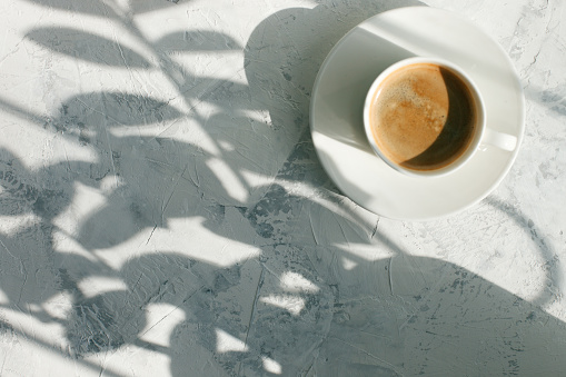 taza de café en la luz de la mañana, sombra del sol, concepto de desayuno de la mañana, vista superior, espacio de copia photo