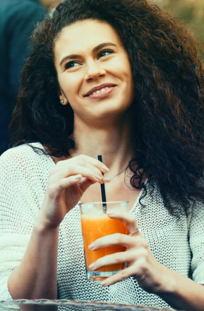istock Beautiful young woman drinking orange juice 1138306823