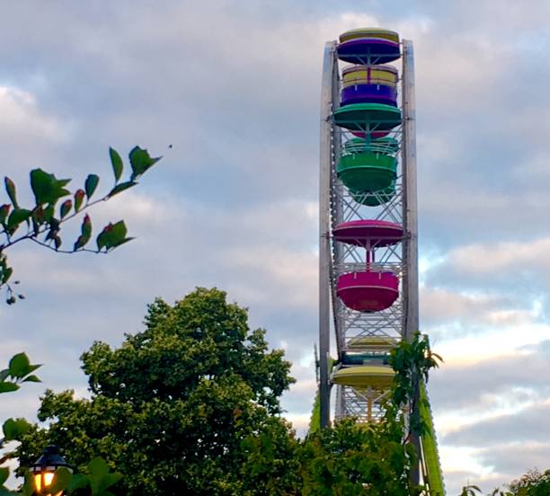 istock A colorful Ferris wheel with clouds trees and blue sky 1138307788