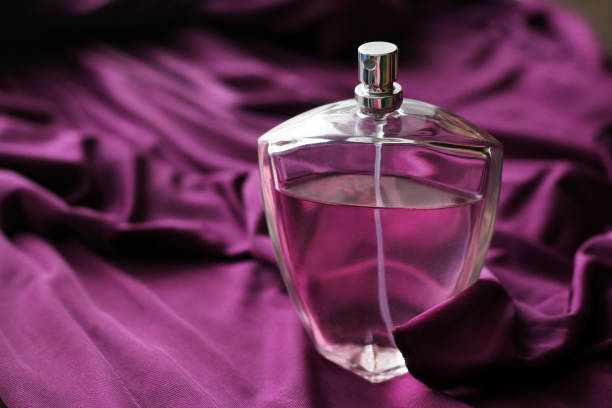 istock Bottle of perfume on a lilac dress 1138314784