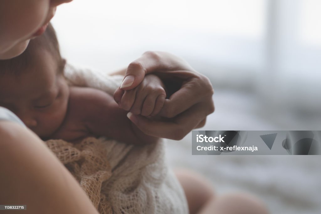Nahe in der Nähe Mutter hält Hände asiatische weibliche Neugeborene und Sonnenlicht am Morgen. Niedliches kleines Mädchen drei Wochen alt. Gesundheit, Pflege, Liebe, Beziehungskonzept. - Lizenzfrei Baby Stock-Foto