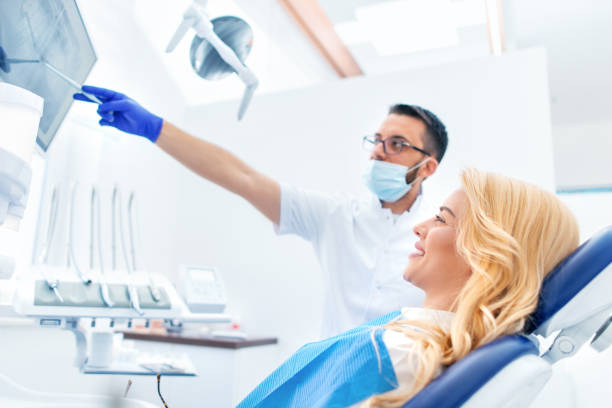 istock Dentist explaining tooth x-rays to a female patient 1138324246