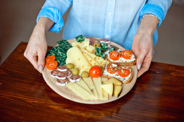 istock Close-up woman holds a cheese plate in her hands 1138326070