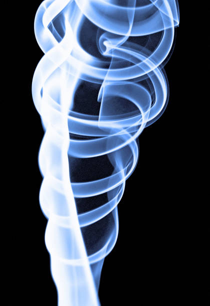 A thread of blue-tinged smoke spirals  upwards against a black background creating circular patterns.