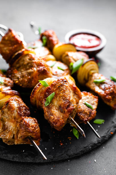 istock Grilled meat skewers, shish kebab on black background 1138334054