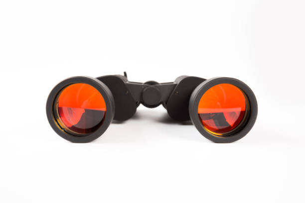 istock Black binoculars with orange lens isolated on white background 1138334646