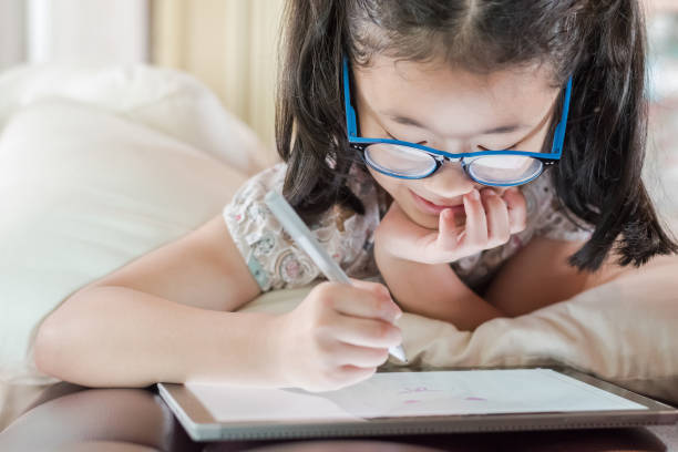 istock Asian school child girl using smart tablet device digital technology drawing on innovative touchscreen surface 1138334752