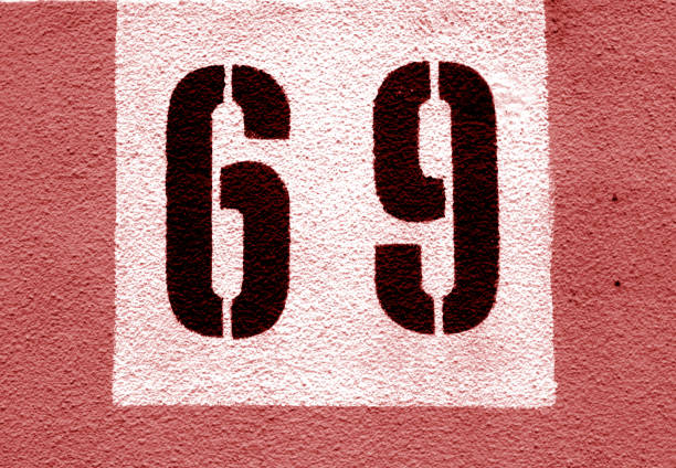 istock Number 69 on cement wall in stencil in red tone. 1138335217