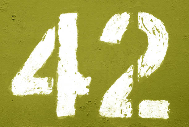 istock Number 42 in stencil on rusty metal wall in yellow tone. 1138337319